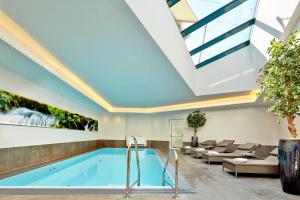 a swimming pool in a building with a skylight at Hotel Gabi in Wals