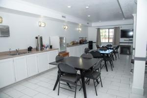 a dining room with tables and chairs and a kitchen at Traveler's inn in Carlin