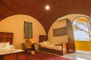 a bedroom with two beds and a wooden ceiling at Seliyaa Siwa Inn Hotel in Siwa