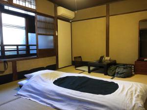 a bedroom with a large bed and a desk at Gojo Guest House in Kyoto
