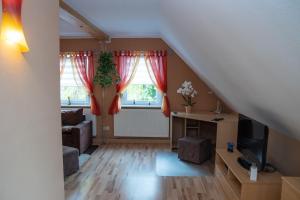 ein Wohnzimmer mit roten Vorhängen und einer Treppe in der Unterkunft Ferienwohnung Smieszek in Niesky