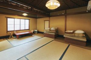 een kamer met twee bedden en een tafel erin bij Gojo Guest House in Kyoto