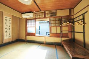 Habitación con ventana y escalera. en Gojo Guest House, en Kioto