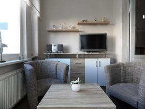 バンシンにあるVilla Diana - 100 m zum Strandの椅子2脚とテレビのあるリビングルーム