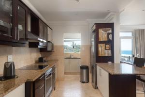 a kitchen with brown cabinets and a counter top at Ballito Manor View 601 in Ballito