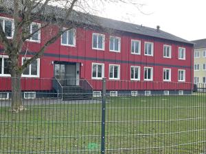 a red building with a fence in front of it at Yebs Hotel in Günzburg