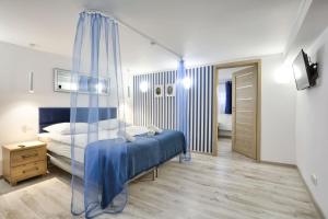 a bedroom with a bed with a blue comforter at Apartament Niebieski in Oleśnica