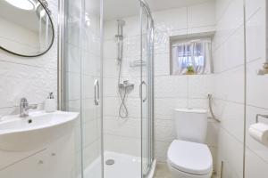 Baño blanco con aseo y lavamanos en Apartament Niebieski, en Oleśnica