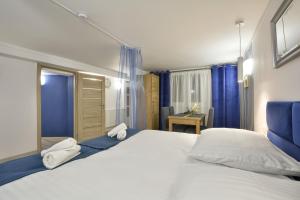 Schlafzimmer mit einem großen weißen Bett und blauen Vorhängen in der Unterkunft Apartament Niebieski in Klein Öls