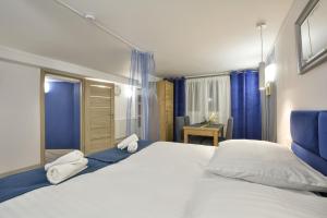 a bedroom with a large white bed with blue curtains at Apartament Niebieski in Oleśnica