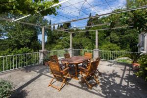 Une table et des chaises en bois sont disponibles sur la terrasse. dans l'établissement Apartments Anka, à Trsteno