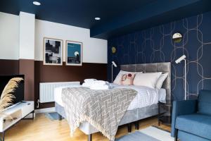 Un dormitorio con una cama y una pared azul. en Bob W Tower of London, en Londres