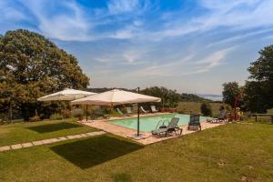 a swimming pool with two chairs and an umbrella at Agriturismo La Gismonda in Bracciano