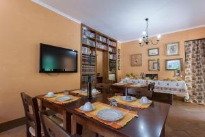 a dining room with a long table and a flat screen tv at Agriturismo La Gismonda in Bracciano