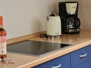 a counter with a coffee maker and a bottle of wine at Haus Wolter in Gengenbach