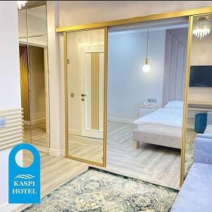Zimmer mit einem Bett und einer Glasschiebetür in der Unterkunft Kaspi Hotel in Oral