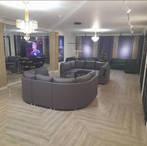 una gran sala de estar con sofás y TV. en Kaspi Hotel, en Uralsk