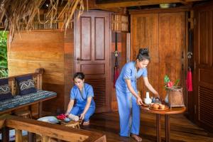 una donna e un bambino in una stanza di Riverside Boutique Resort, Vang Vieng a Vang Vieng