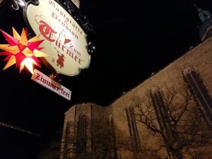 un cartello per un ristorante di fronte a un edificio di Gaststätte & Pension Zum Türmer a Annaberg-Buchholz