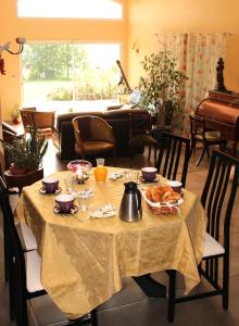 ein Tisch mit einem Tischtuch drauf mit Essen drauf in der Unterkunft Le Clos des Malézolles in Saint-Germain-Laval