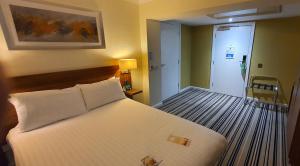 a bedroom with a large white bed in a room at Holiday Inn Swindon by IHG in Swindon +87 photos