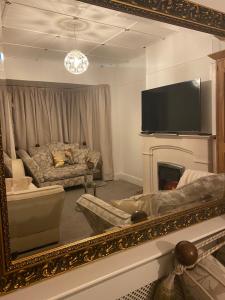 a living room with a mirror and a couch and a tv at Citretum Angulus in Southampton