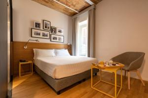 a bedroom with a bed and a chair and a table at Coronari Palace in Rome