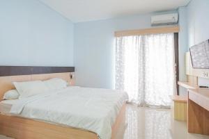 Un pat sau paturi într-o cameră la RedDoorz near Muaya Beach Jimbaran +15 fotografii