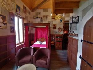1 dormitorio pequeño con 1 cama y 2 sillas en Le Making Of Chambres d'Hôtes insolites et Familiales, en Thairé