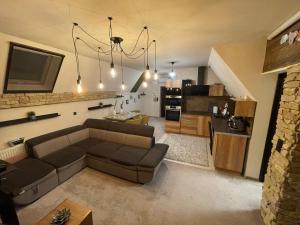 uma sala de estar com um sofá e uma cozinha em Penthouse privát Jakuzzival Smeraldo Villa em Siófok