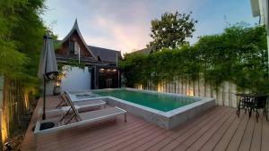 a backyard with a swimming pool and a wooden deck at MONO LUX Villa x MonthStayZ Thailand in Chalong 