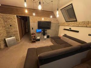 uma sala de estar com um sofá e uma televisão de ecrã plano em Penthouse privát Jakuzzival Smeraldo Villa em Siófok