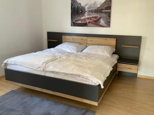 a bedroom with a large bed with a wooden headboard at D&D Apartment in Kolbermoor