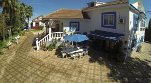 Cette maison dispose d'une terrasse avec une table et un parasol. dans l'établissement Casa Rural Finca Real De Niebla, à Niebla