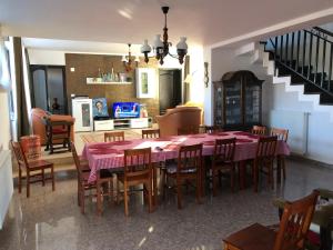 a dining room with a table and chairs and a kitchen at Pensiunea Crețișoara in Câmpulung