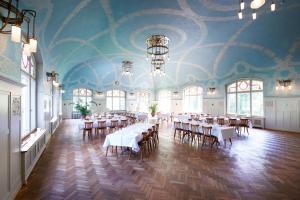 une chambre avec des tables et des chaises dans une pièce dotée d'un plafond dans l'établissement Kurhaus Bergün, à Bergün