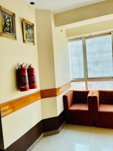 a waiting room with a couch and a window at Plaza Inn Hotel in Rahimyar Khan