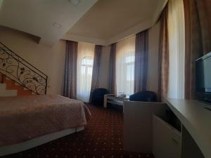 a hotel room with a bed and a flat screen tv at Jermuk Verona Resort in Jermuk