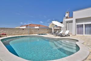 a swimming pool with two chairs and a house at Casa Siesta in Murine
