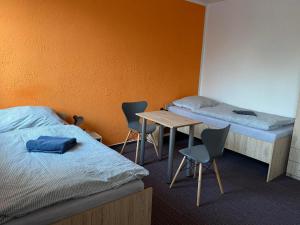 a room with two beds and a table and chairs at Kolík Apartmány in Bohumín