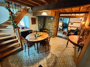 a dining room with a table and chairs and a staircase at Le Clos des Brumes in Stoumont
