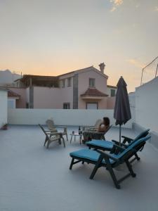 a person sitting on a roof with chairs and an umbrella at Vivienda Vacacional La Aldea de San Nicolas in La Aldea de San Nicolas