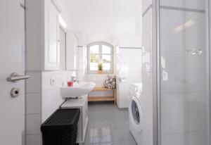 a white bathroom with a sink and a shower at "Villa Sonnengarten", FeWo 3 in Boltenhagen