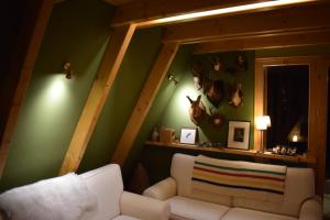 ein Wohnzimmer mit einem weißen Sofa und einer grünen Wand in der Unterkunft Tarski Proplanak in Bajina Bašta