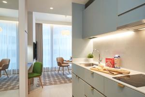 a kitchen with a sink and a dining room at Citadines Raffles Place Singapore in Singapore