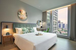 a bedroom with a large white bed and a large window at Citadines Raffles Place Singapore in Singapore