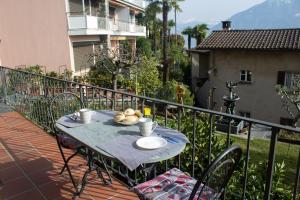 une table avec des assiettes de nourriture sur un balcon dans l'établissement Panoramic Orselina, à Orselina