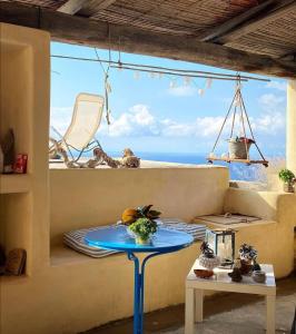 a table in a room with a view of the ocean at Alicudi Giardino dei Carrubi- al gradino 365 in Alicudi