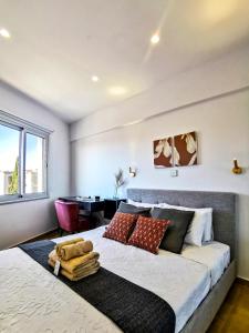 ein Schlafzimmer mit einem großen Bett und einem Tisch in der Unterkunft Phaedrus Living : Seaside Luxury Flat Lighthouse 70 in Paphos