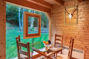a dining room with a glass table in a log cabin at Pikol Lake Village Wine Estate in Nova Gorica